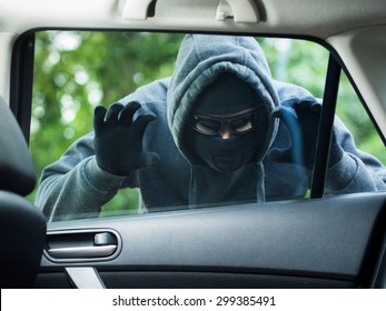 Transportation crime concept .Thief stealing bag from the car