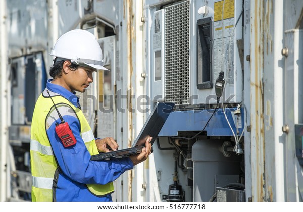 transportation engineer with pc checking reefer\
container box in logistic\
zone