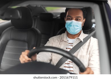 Transportation, Health And People Concept - Male Indian Driver Wearing Face Protective Mask For Protection From Virus Disease Driving Taxi Car