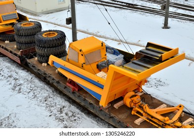 Transportation Of Heavy Mining Equipment By Rail. Disassembled Yellow Mining Truck Loaded Onto A Cargo Railway Platform. Multimodal Logistics Of Transportation Of Oversized Cargo