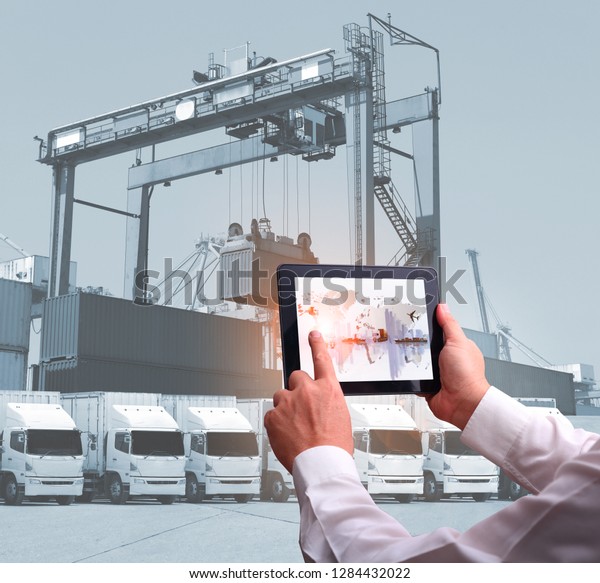 transportation import export concept,Man hand holding\
cell phone or tablet  automate wireless for control drlivery\
shipment 