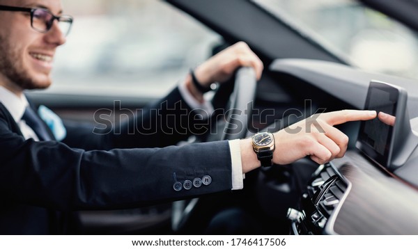 Transportation\
And Modern Technology Concept. Smiling man in glasses checking\
navigation system on car dashboard\
screen