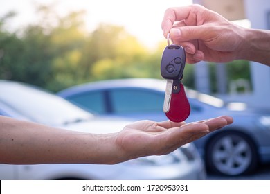 Transportation And Ownership Concept Customer And Salesman With Car Key Outside.