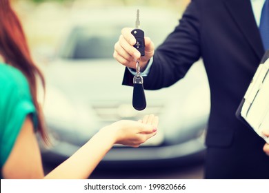 Transportation And Ownership Concept - Customer And Salesman With Car Key Outside