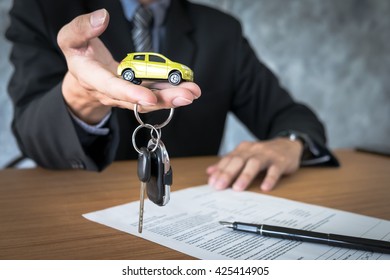 Transportation And Ownership Concept - Customer And Salesman With Car Key