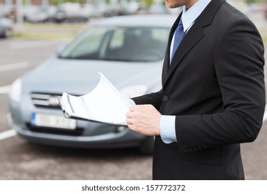 Transportation And Ownership Concept - Man With Car Documents Outside