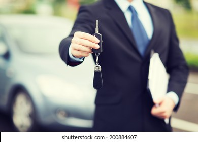 Transportation And Ownership Concept - Man With Car Key Outside