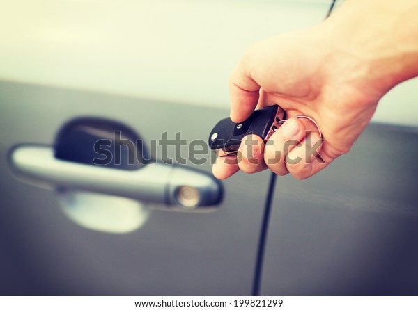 transportation and ownership concept - man with\
car key outside