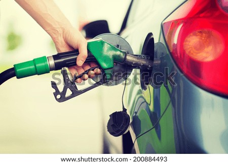 transportation and ownership concept - man pumping gasoline fuel in car at gas station