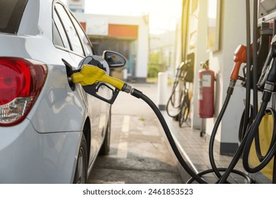 Transportation and ownership concept - woman pumping gasoline fuel in car at gas station during Russia-Ukraine war that oil or gasohol price high. 