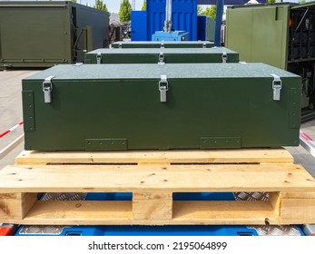 Transportation Of Production Equipment. Closed Boxes For Transporting Equipment. Green Cases Are On Wooden Pallets. Cases With Industrial Equipment In Open Air. Dark Green Cases With Steel Locks