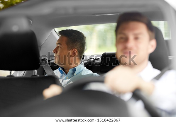 transportation, taxi and people concept -\
middle aged male passenger on back seat and car\
driver