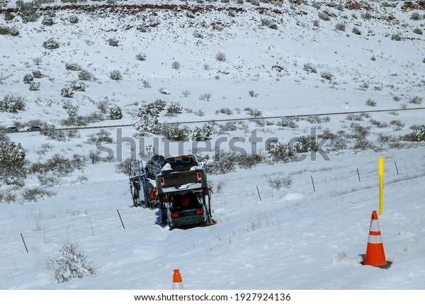 Transportation trailer truck of car on\
semi-trailer on new cars on the highway hauler accident truck off\
road through cold weather\
conditions
