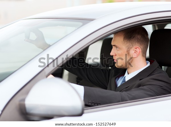 transportation and vehicle concept - businessman\
driving a car