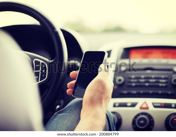 transportation and vehicle concept - man using phone\
while driving the\
car