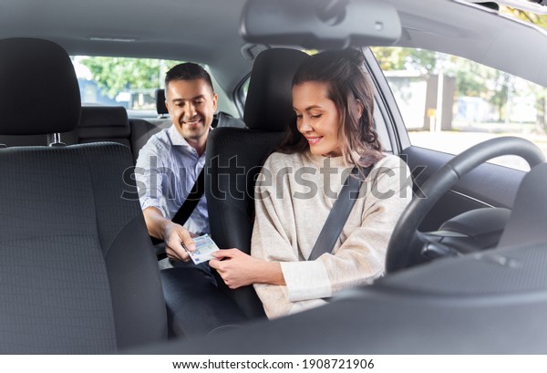 transportation, vehicle and payment\
concept - female car driver taking money from male\
passenger