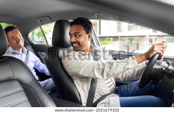 transportation,\
vehicle and people concept - happy smiling middle aged male\
passenger talking to taxi car\
driver