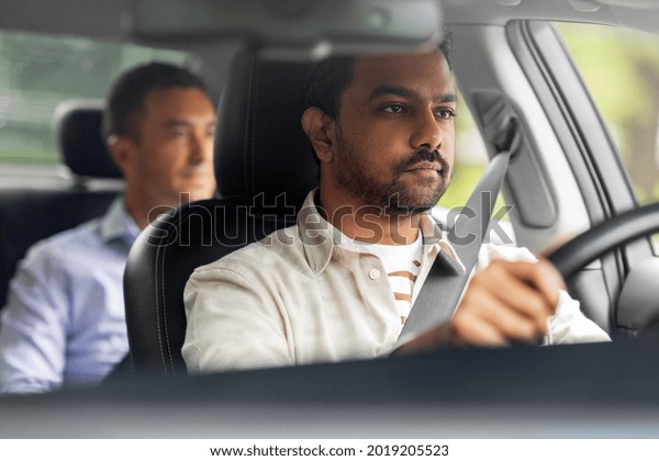 transportation, vehicle and people concept -\
indian male driver driving car with\
passenger