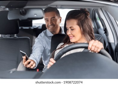 transportation, vehicle and people concept - male passenger showing smartphone to happy smiling female taxi car driver - Shutterstock ID 1908722074