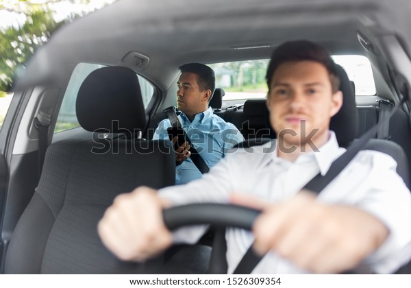 transportation,\
vehicle and people concept - middle aged male passenger with\
smartphone on back seat and car\
driver