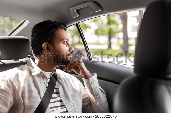 transportation, vehicle and people concept - thinking\
indian male passenger in taxi\
car