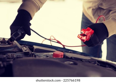 Transportation, Winter And Vehicle Concept - Closeup Of Man Under Bonnet With Starter Cables