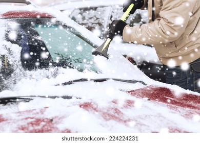 Transportation, Winter, Weather, People And Vehicle Concept - Closeup Of Man Cleaning Snow From Car Windshield With Brush