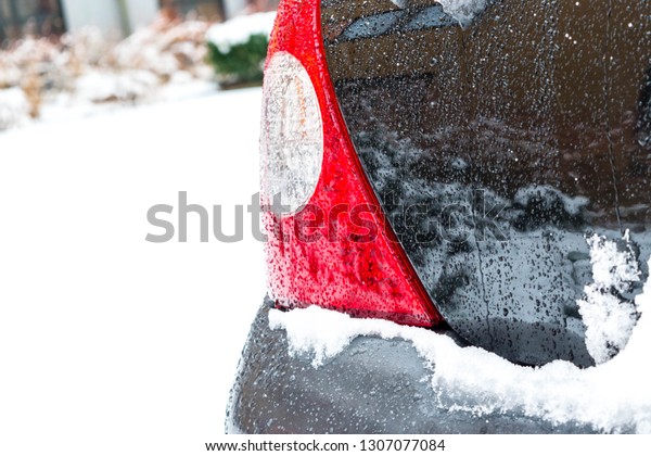 Transportation, winter,\
weather, vehicle concept. Detail on the rear light of a car.\
covered in snow and icy rain in winter. Blizzard Snowfall icy rain\
for weather\
concept.