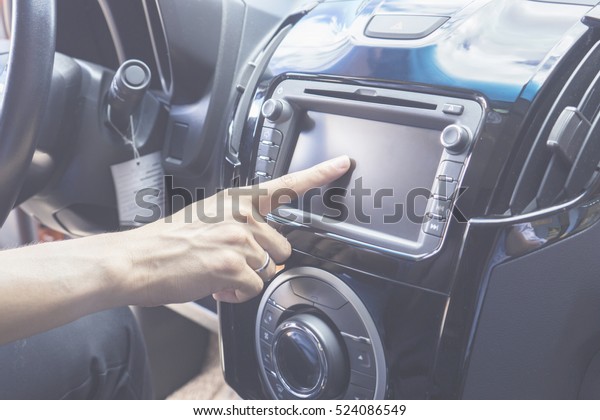 Transportation,technology and vehicle concept - man\
using car system control pushing panel button touch screen\
interface modern design,GPS and DVD ,Vintage\
color