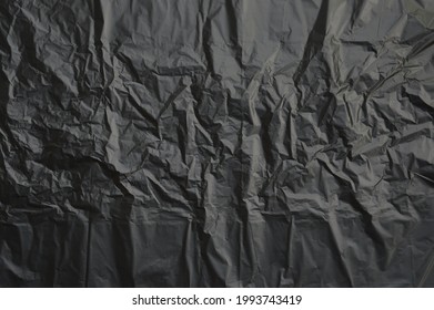 Trash Bag Texture Background, Black Crumpled Plastic Wall As Wallpaper, Top View Close Up.