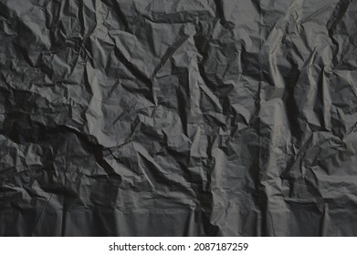 Trash Bag Texture Background, Black Crumpled Plastic Wall As Wallpaper, Top View Close Up.