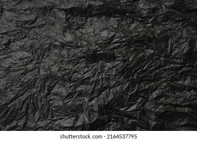 Trash Bag Texture Background, Black Crumpled Plastic Wall As Wallpaper, Top View Close Up.