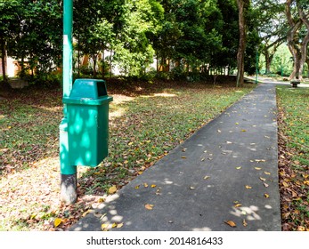 Trash Bin On A Lamp Post Along A Walking Path In The Park