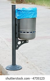 A trash bin on a side of a pedestrian street