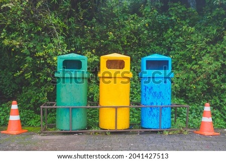 Trash bins and different garbage in front of national park entrance, Waste recycling concept