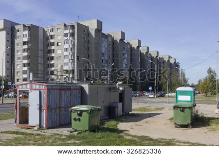 Trash cans and bio toilet near mini markets of a fast food on the street of the mass production residential city area