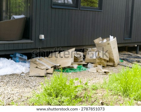 trash and empty carboard boxes behind a house, a daylight shot, no people