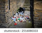 Trash and garbage littering the path to a residential building in London, England