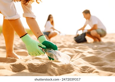 Trash on the beach. Volunteers activists collects garbage cleaning of beach coastal zone. Woman mans with trash in garbage bag on ocean shore. Earth day. - Powered by Shutterstock