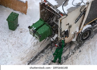 Trash Pickup In Winter - Garbage Collector Loading Garbage Truck, High Angle View