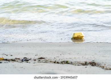 Trash yellow styrofoam fast food container for take away service, a lot plastic spilled trash on sea nature beach sand sun day, problem earth ocean pollution contamination, environmental protection