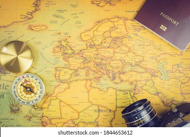 Travel accessories concepts : It's time to go to travel around the world - The image of a world map with essentials accessories - passport, compass and camera. Vintage tone style. Top view picture.