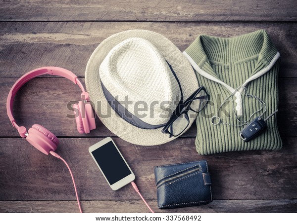 Travel accessories. Shirts,\
hats,smart-phone,earphone, wallets, glasses, car keys ready for the\
trip.