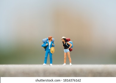 Travel and Adventure concepts. Traveler miniature mini figure with backpack stand and walking on road - Powered by Shutterstock