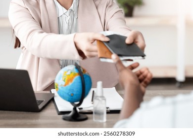 Travel Agency. Female Manager Giving Booked Tickets To African American Tourists Couple Sitting In Modern Office, Wearing Medical Face Masks. Tourism Management, Vacation Tour. Selective Focus - Powered by Shutterstock