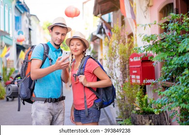 Travel Asia. Young couple looking at phone travelling Asia.