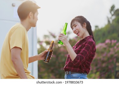 Travel Asian couple having fun drinking beers standing in front of vintage camper mini van. Happy people enjoying drink and camping by the nature. Concept of leisure vacation lifestyle. - Powered by Shutterstock