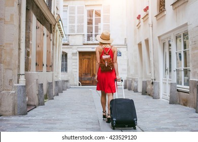 travel background, woman tourist walking with suitcase on the street in european city, tourism in Europe
