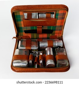 Travel bag for gentleman personal hygiene. Vintage men's grooming and travel kit with shaving tools, toothbrush holder, soap box, razor box, brown leather case, chrome plated, made in 1950s. - Powered by Shutterstock