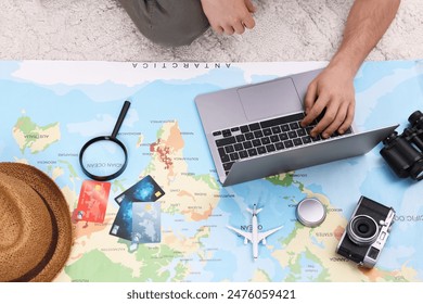 Travel blogger using laptop and map for planning trip, top view - Powered by Shutterstock